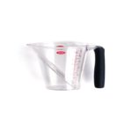 An Oxo liquid measuring cup over a white surface.