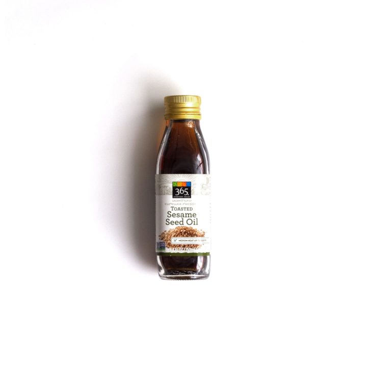 A bottle of toasted sesame oil over a white background.