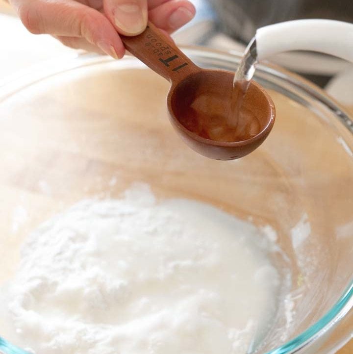adding 1 tablespoon of hot water to a bowl of sweet rice flour