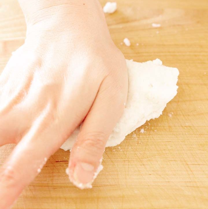 kneading sweet rice dough on a wood cutting board