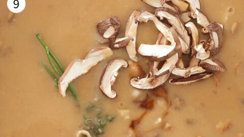 Thickened vegan gravy in a pan with dried shiitake mushrooms added.