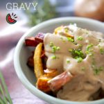 Vegan mushroom gravy over a bowl of oven roasted vegetable fries placed on a pink and blue cloth.