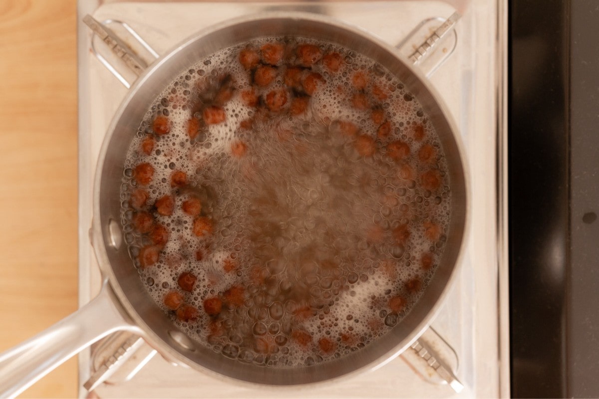 Boba (tapioca pearls) boiling in a small pot of water.