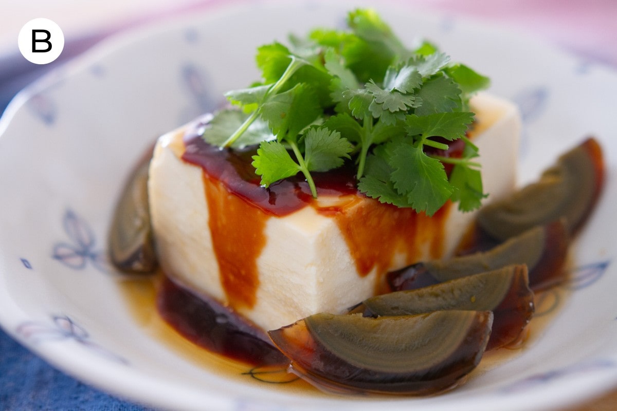 A photo labeled with "B" of silken tofu and wedges of century egg in a shallow bowl, topped with soy sauce paste, sesame oil, and cilantro.