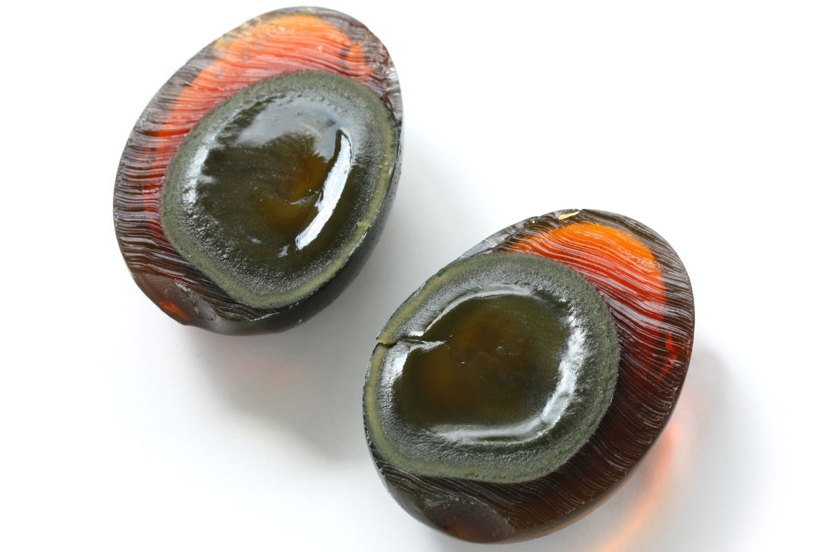 Top down view of two halves of a century egg to show the creamy yolk and translucent egg "whites" glowing with natural sunlight shining through.
