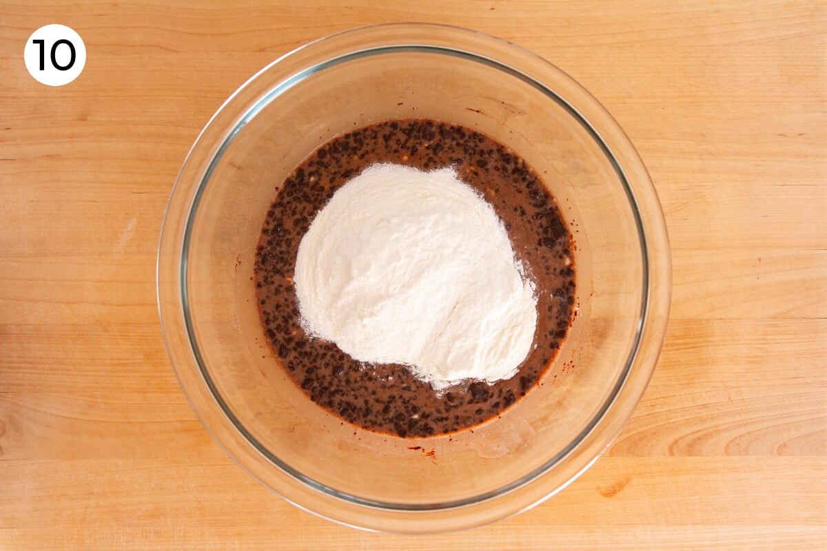 Mixed dry ingredients added to the top of the wet batter in the large glass bowl, labeled with a circled number "10."