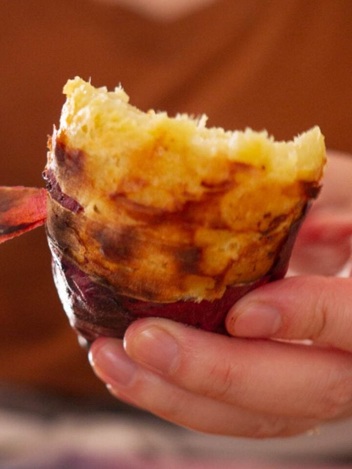 Close up view of Cindy removing the peel of half of an air-fried Japanese sweet potato by hand.