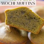 Close up view of stacked matcha mochi muffins, one cut in half to show the golden crust on the outside and moist center. Text overlay that reads, "easy Matcha Mochi Muffins" and "thesoundofcooking.com" with a small illustrated watermelon logo.