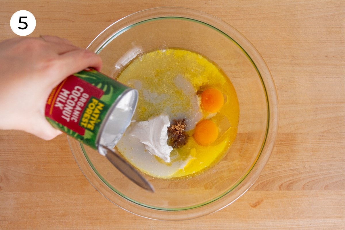 Cindy pouring coconut milk from the can into the large mixing bowl with light brown sugar, sugar, vanilla extract, two eggs, and butter, labeled with a circled number "5."