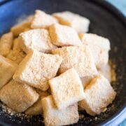 Stack of cut injeolmi (Korean sweet rice cake) on a black serving plate.