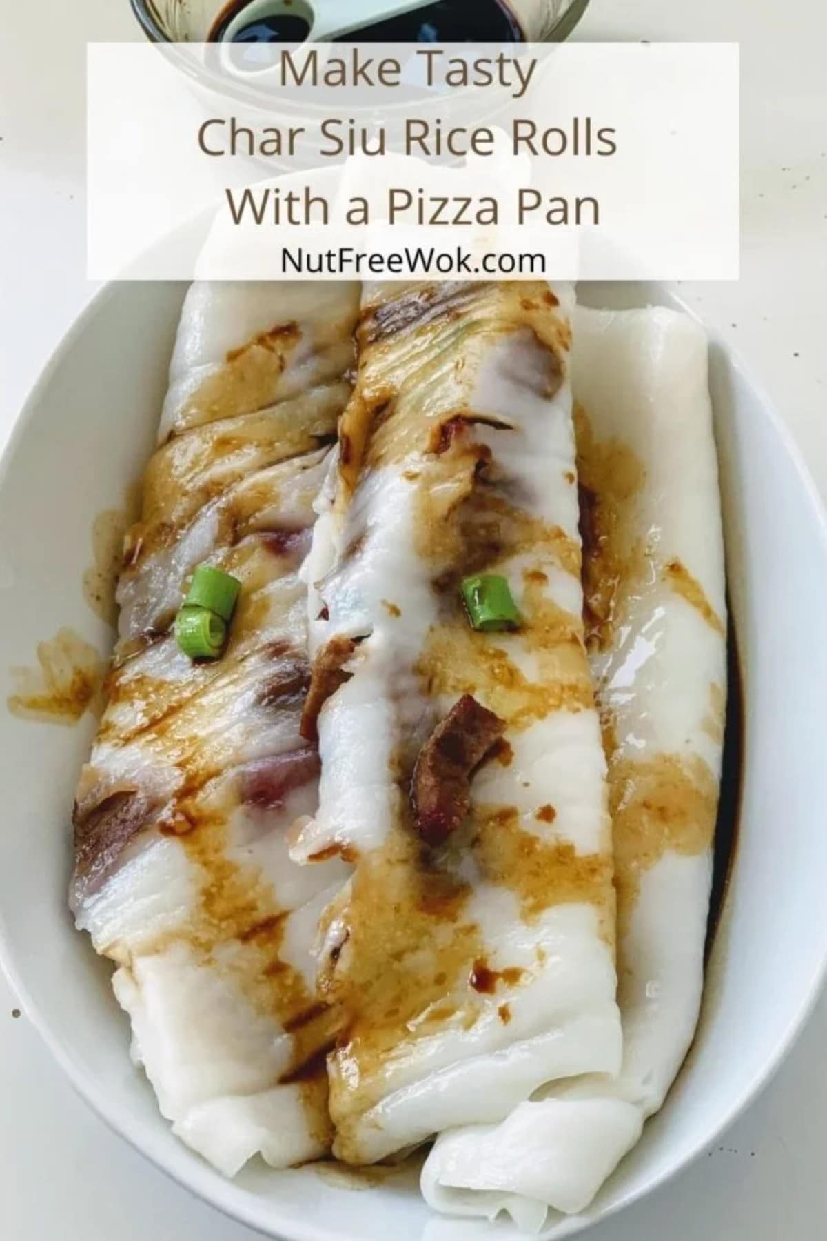 Three rice noodle rolls on a white plate with sauce and fresh cut scallions on top.