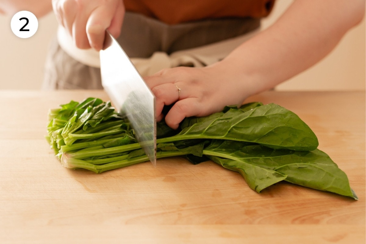 Cindy cutting a bunch of Taiwan spinach about two inches from the end, labeled with a circled number "2."