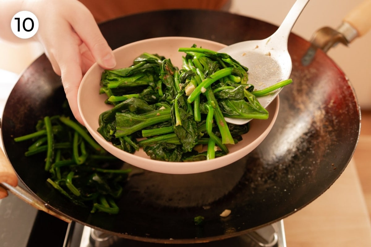 Cindy using a metal spatula to dish out just stir-fried spinach into a pink serving plate, labeled with a circled number "10."