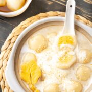 Vietnamese glutinous rice balls in a bowl with a spoon in it.