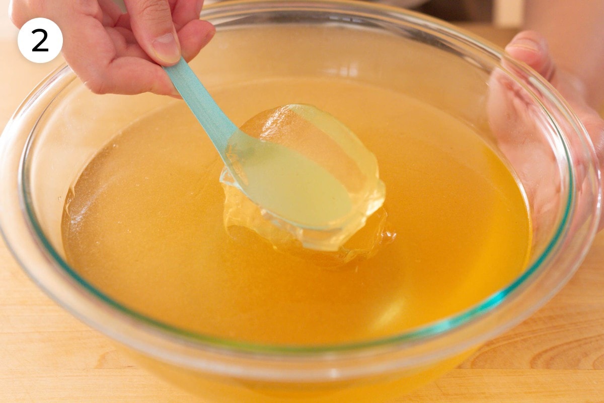 Scooping fresh aiyu step 2: Cindy scooping fresh aiyu jelly up from a large bowl using a turquoise Asian soup spoon.