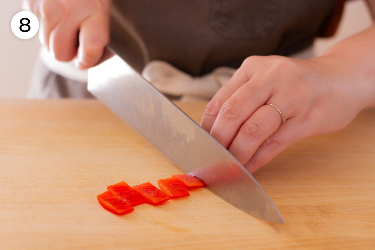 Recipe step 8 (optional): Cindy cutting a thin strip of red bell pepper (skin-side) into ½-inch (about 13 millimeters) wide pieces.