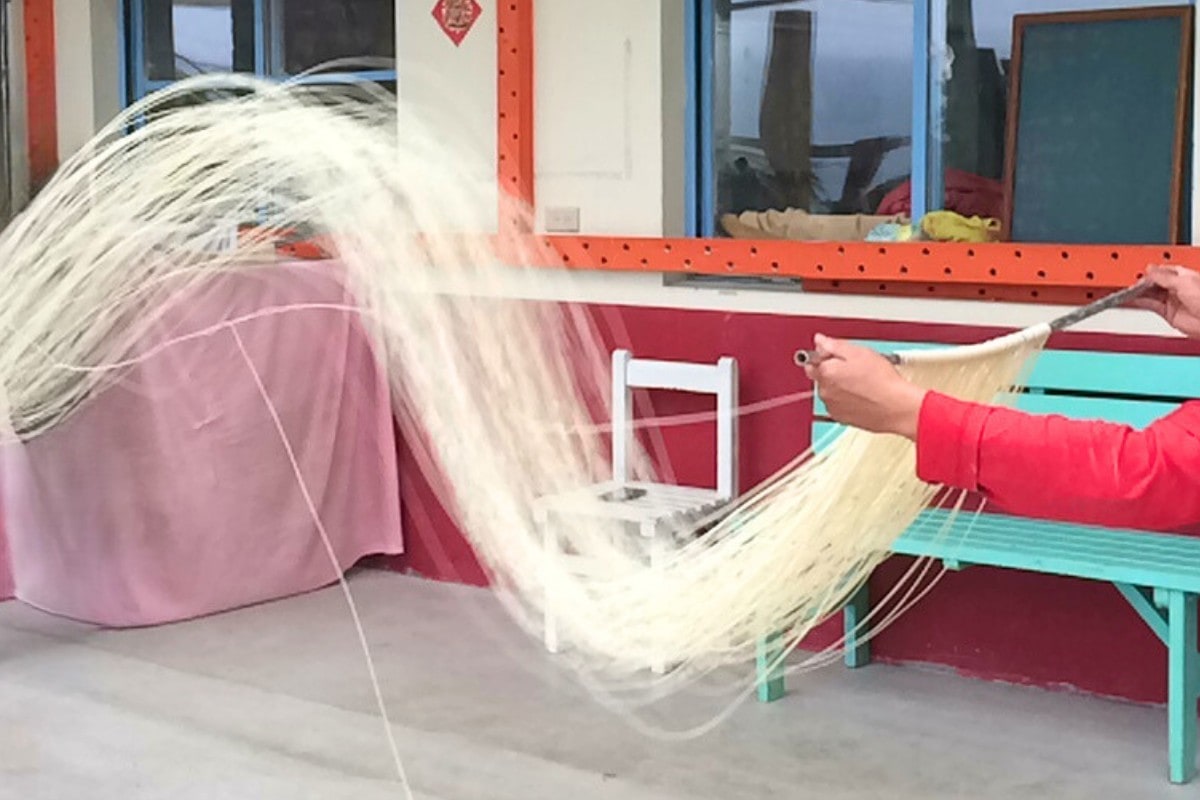 Longevity noodles being hand-pulled at a noodle factory in Taiwan.