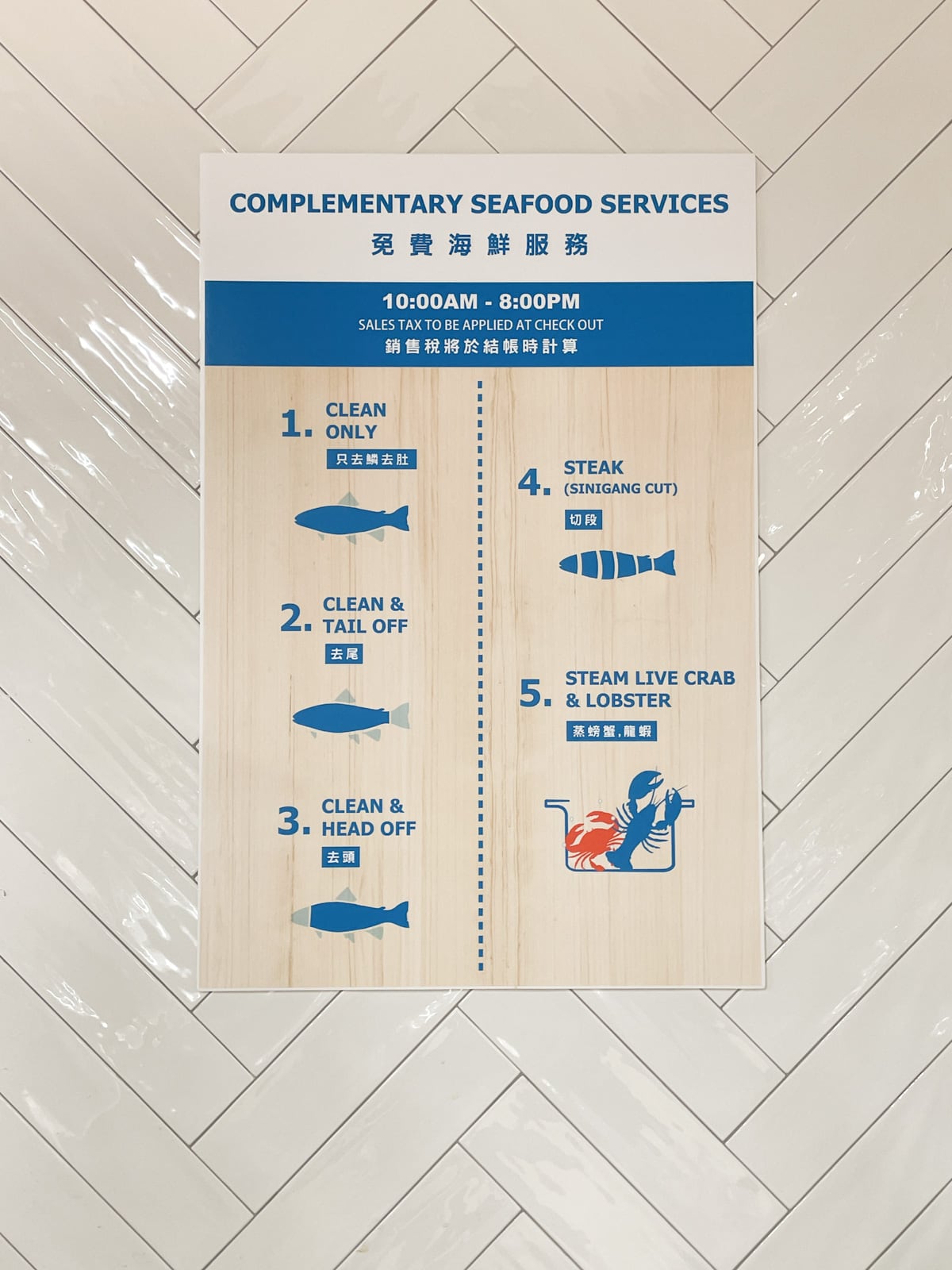 A poster from the seafood section at a 99 Ranch Market showing the "Complementary Seafood Services" available to customers, including 1) Clean Only, 2) Clean and Tail Off, 3) Clean and Head Off, 4) Steam (Sinigang Cut), and 5) Steam Live Crab and Lobster.
